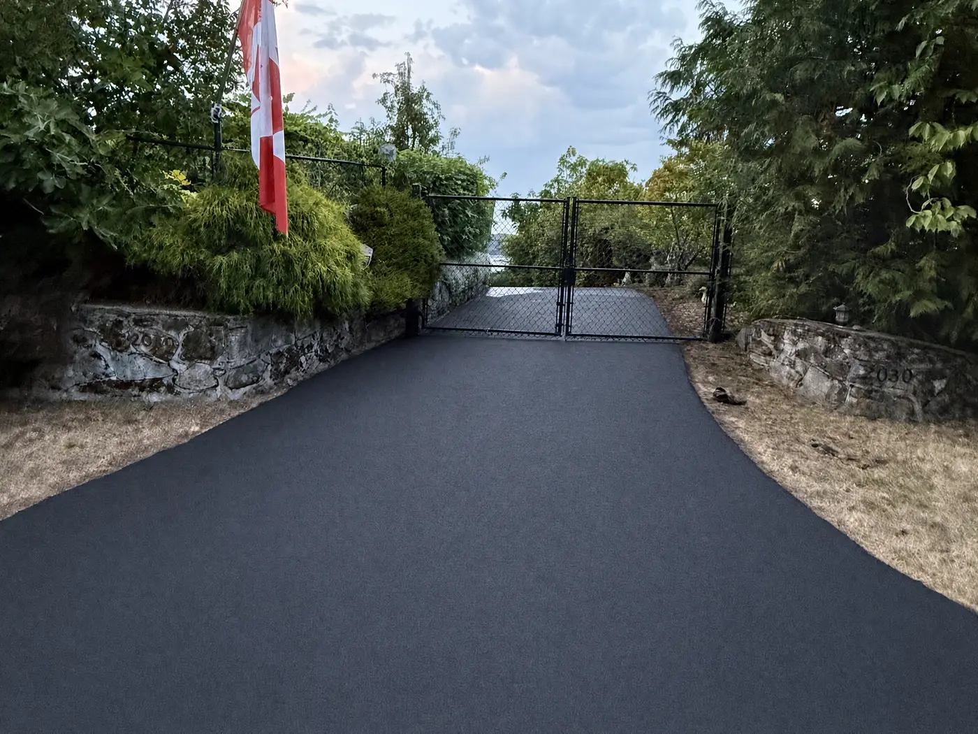Freshly sealcoated driveway leading to an estate gate