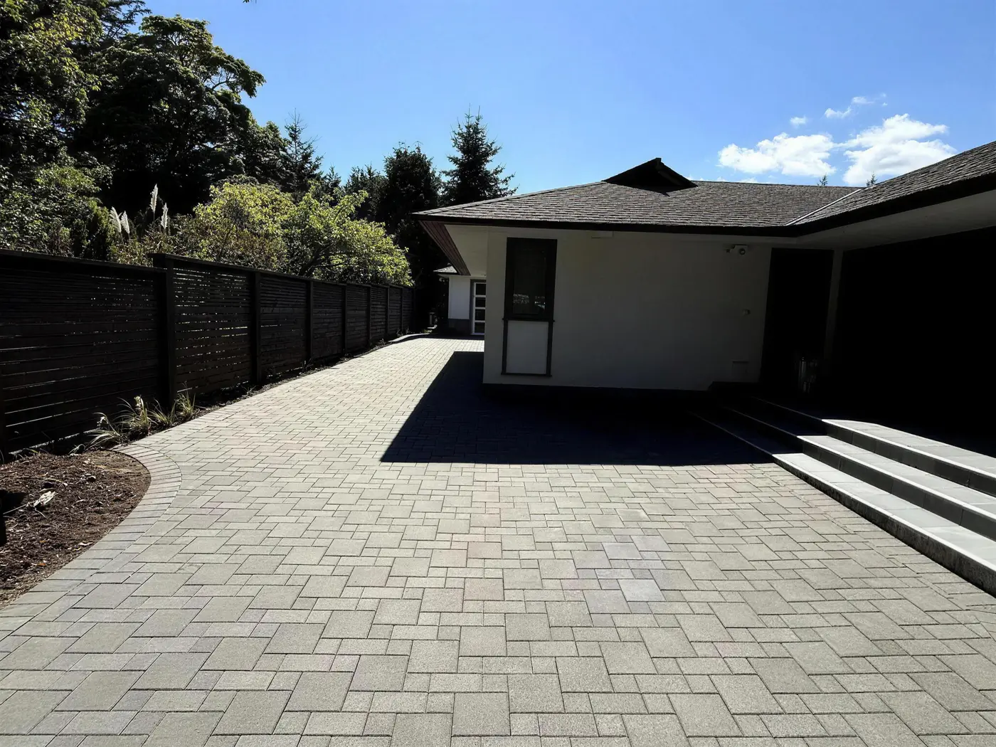 Paver driveway and modern home after restoration and sealing